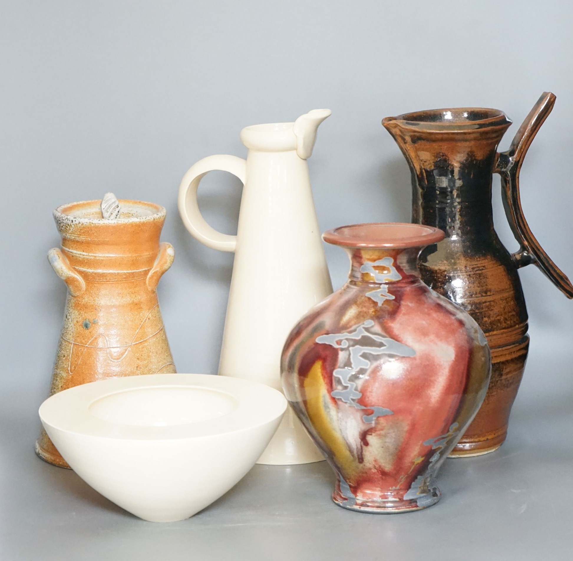 Studio pottery - a Duncan Beattie large stoneware jug, a Trevor Chaplin stoneware lidded jar, an Andrew Mason ruby and silver lustre vase and two Julian Bellmont cream glazed items – a jug and a similar bowl 33cm